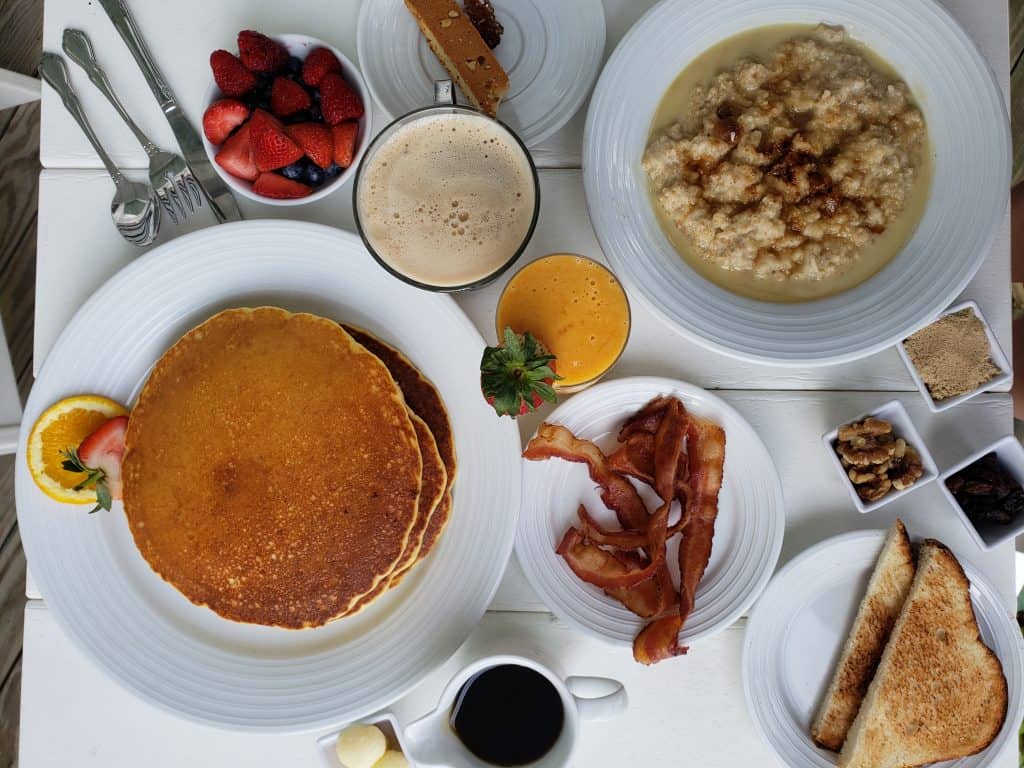 Plates of breakfast foods on a table.