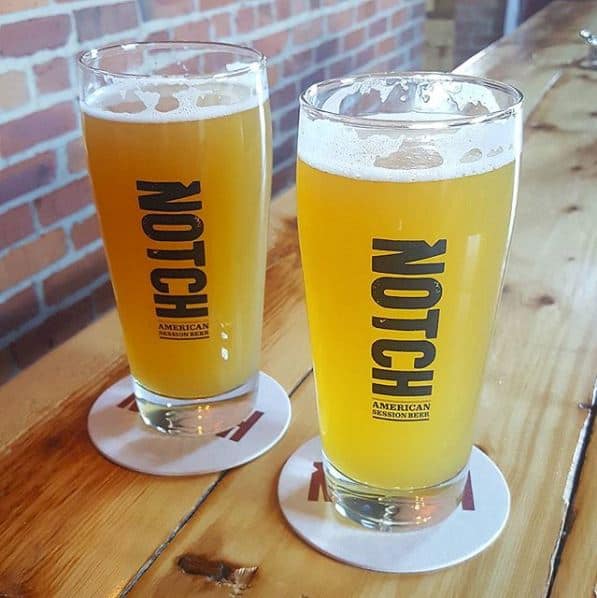 Two glasses of beer on a table.