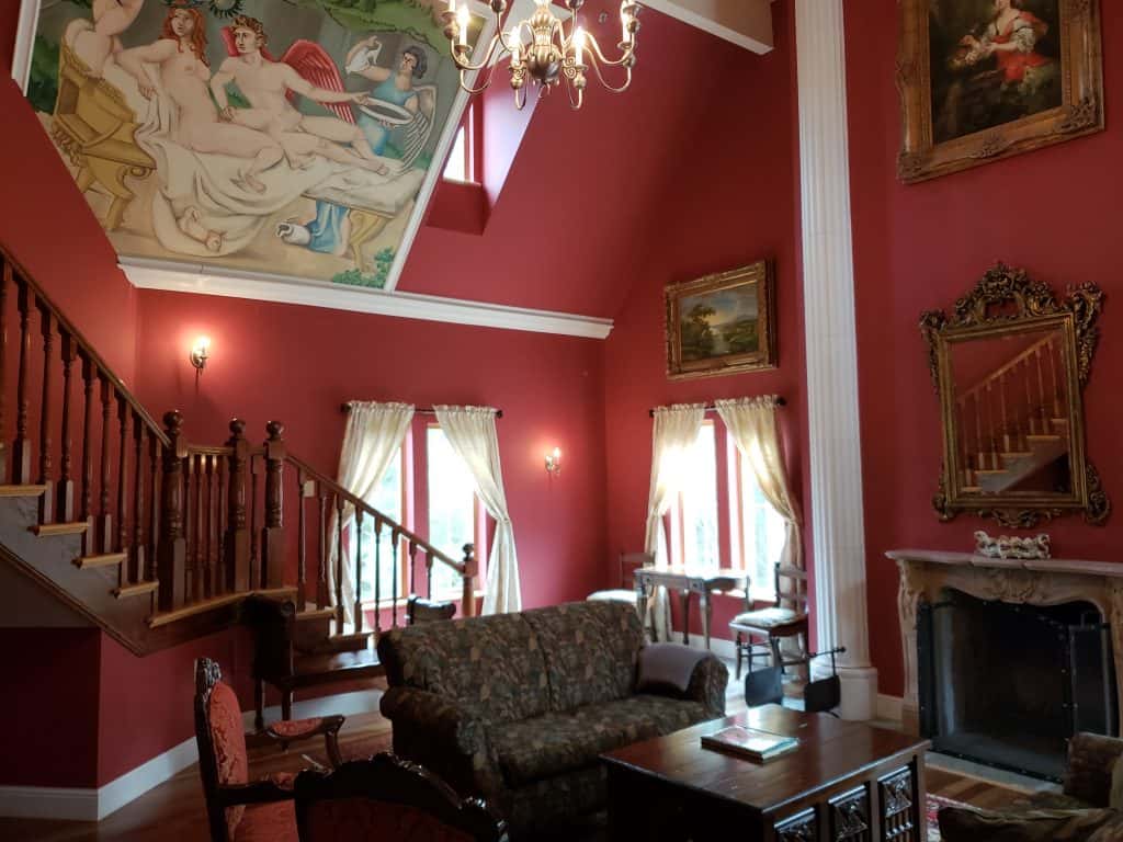 A red living room with chairs and a fireplace.