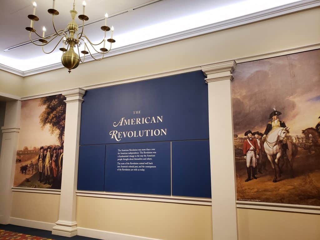 An exhibit with a blue wall speaks about the American Revolution indoors.