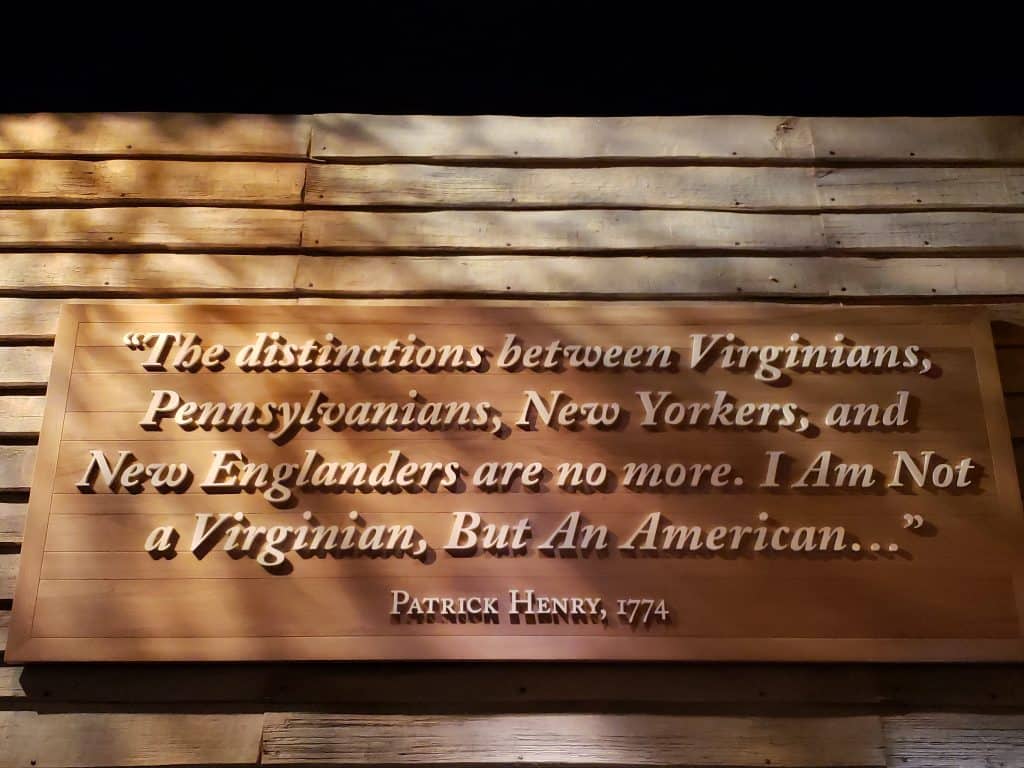 Writing on a wooden plaque that says \"The distinctions between Virginians, Pennsylvanians, New Yorkers, and New Englanders are no more. I Am Not a Virginian, But An American.\" Patrick Henry, 1774.