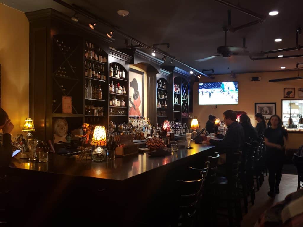 People sit at barstools at a bar.