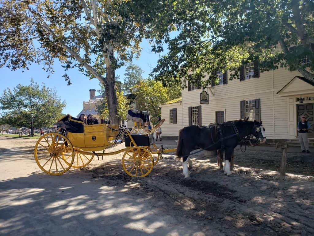 Two horses pull a yellow carriage.