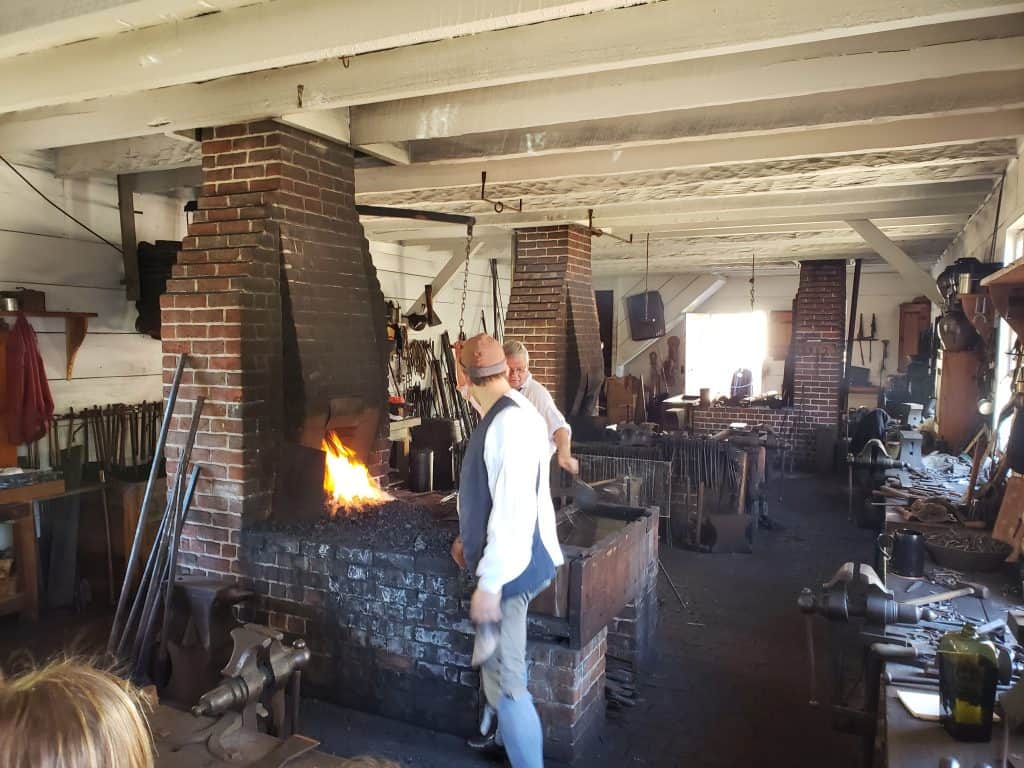 People stand next to a fireplace indoors.