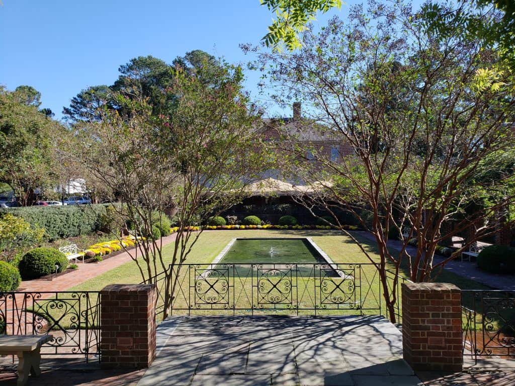 A backyard is empty but has a fountain.