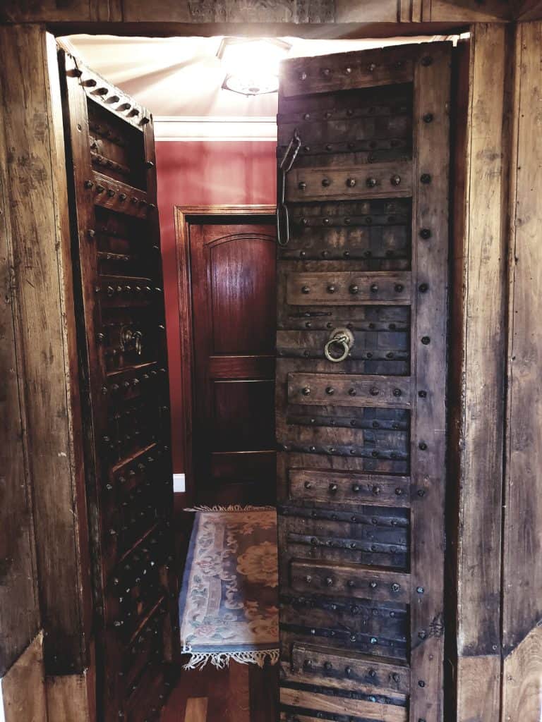 A wooden door is opened to show another door inside