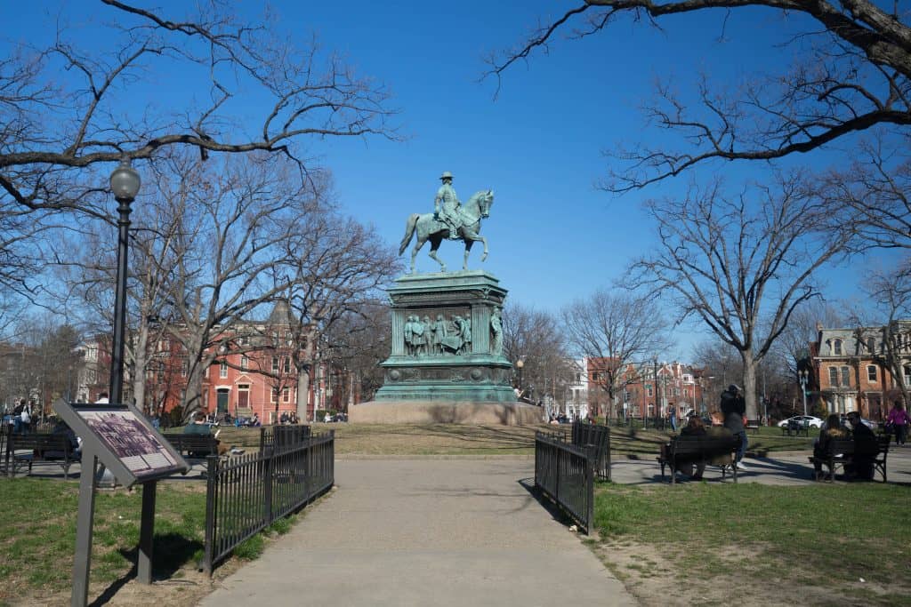 A green statue of a man sitting on a horse.