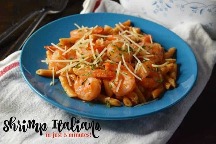 A blue plate is filled with pasta, shrimp, and cheese.