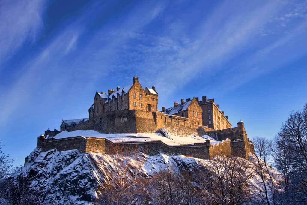 A castle is dusted with snow in the late afternoon winter sunset.