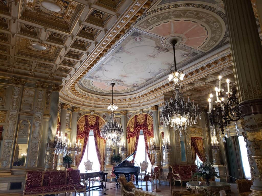 A sitting room is filled with a piano and seats.