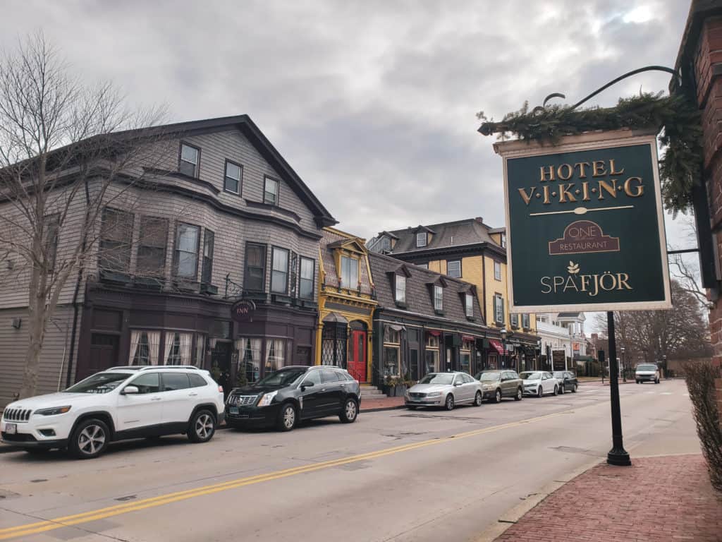 Cars parked on the street lined by shops. A sign says Hotel Viking.