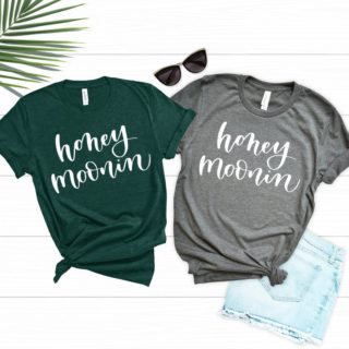 Two shirts that each say Honeymoonin'. One is green and one is grey.