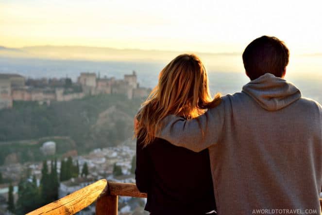 A couple looks out over a scenic vista of a romantic European destination