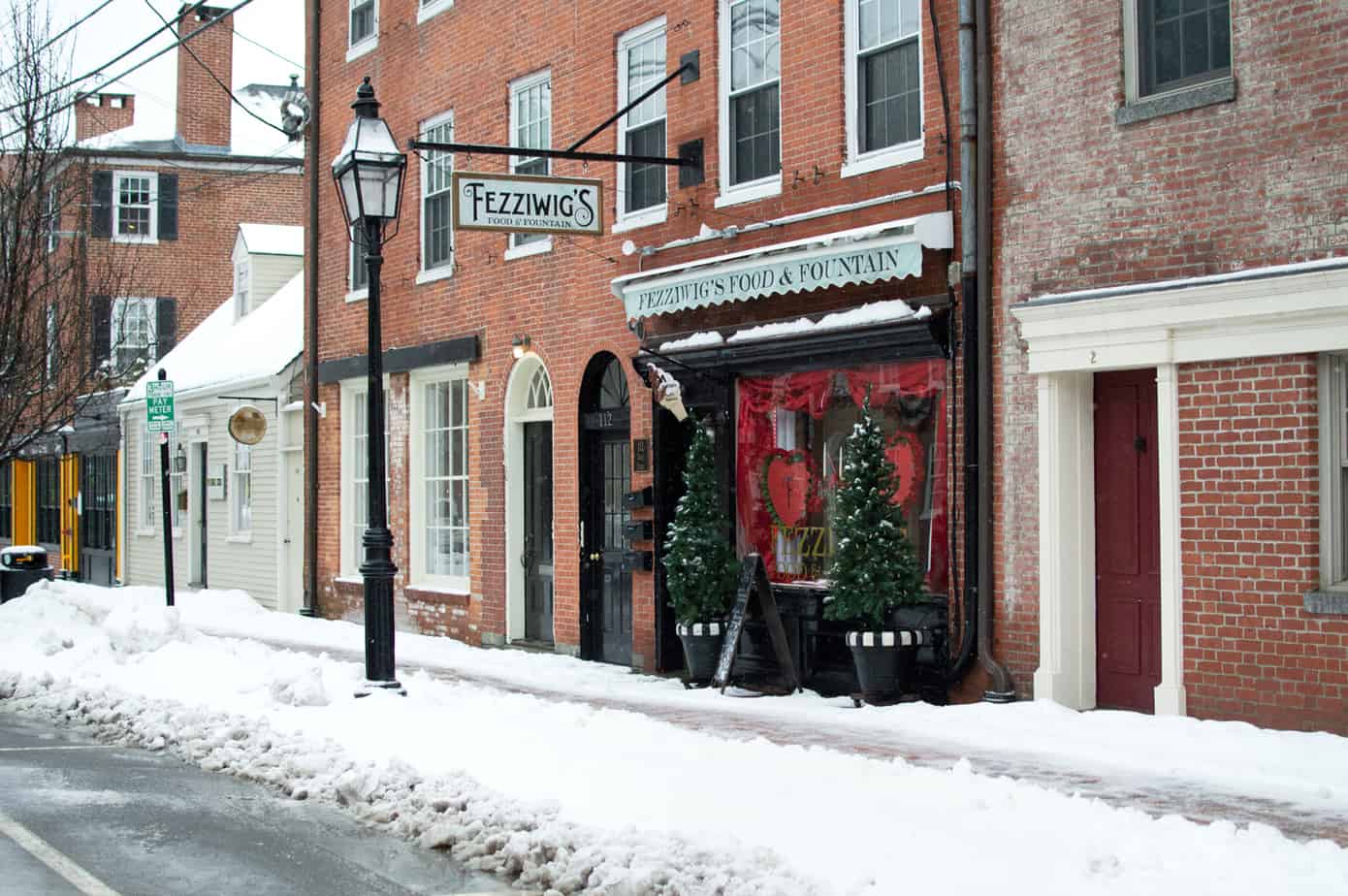 A row of stores with two potted trees out front of Fezziwigs Portsmouth New Hampshire