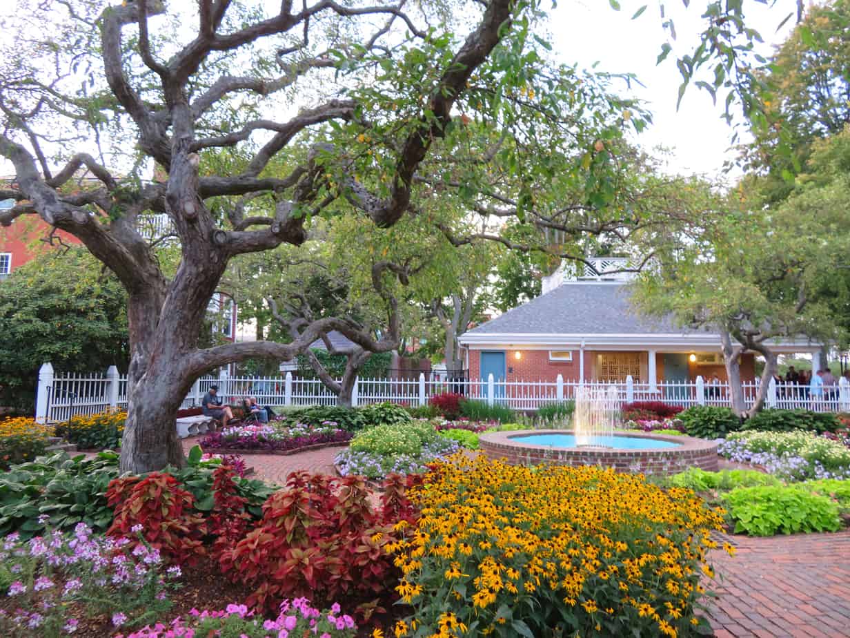 Colorful bushes, flowers and trees in the foreground with a building in the distance in Portsmouth New Hampshire