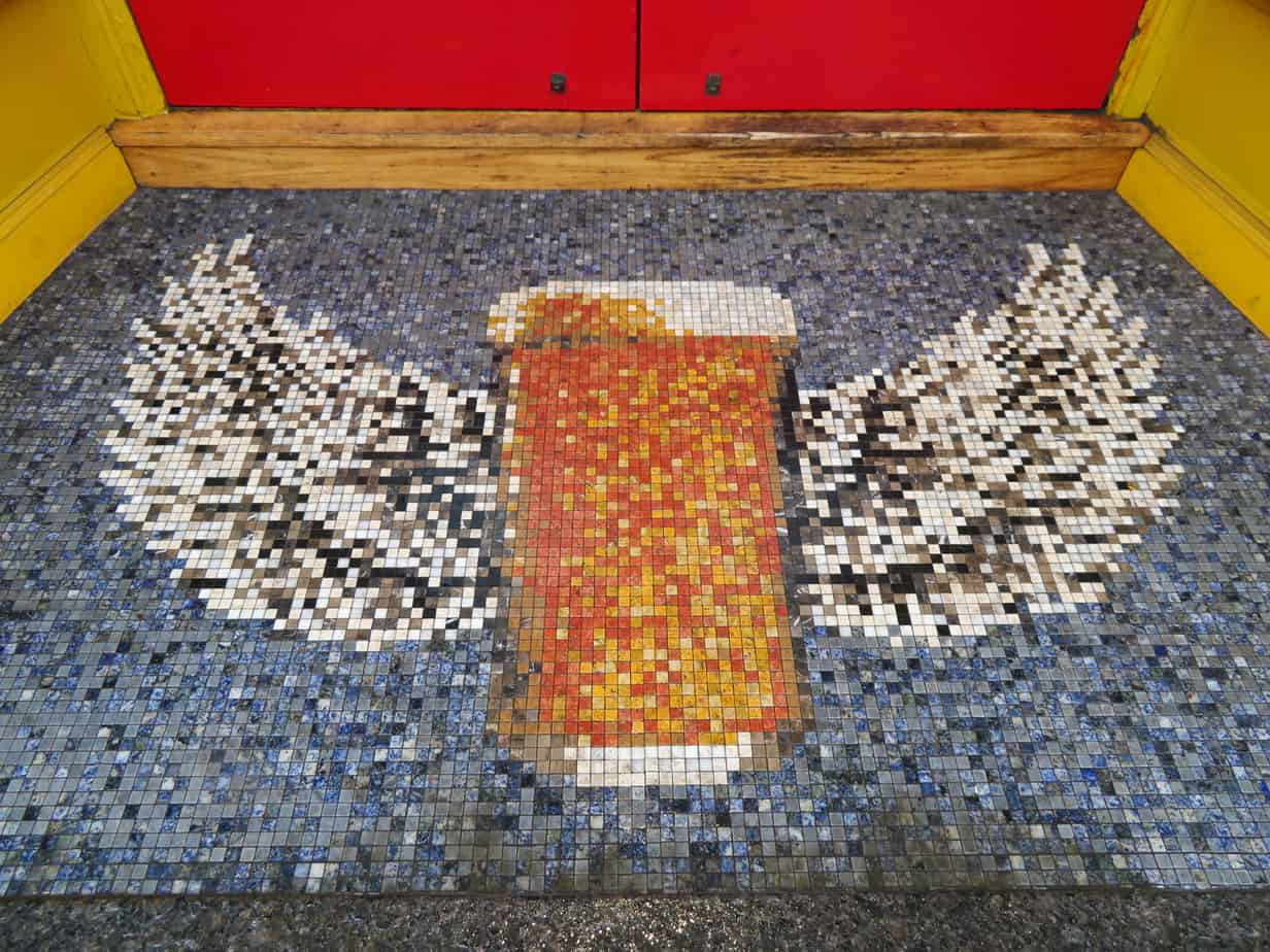 A mosaic design of a beer glass with wings