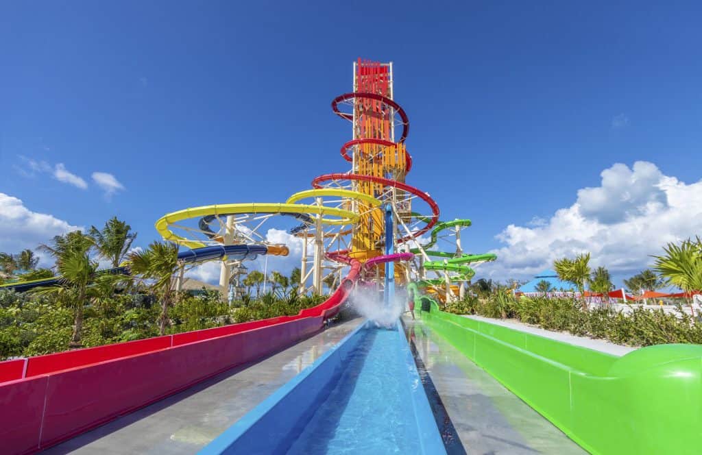 A rainbow water slide under a blue sky.