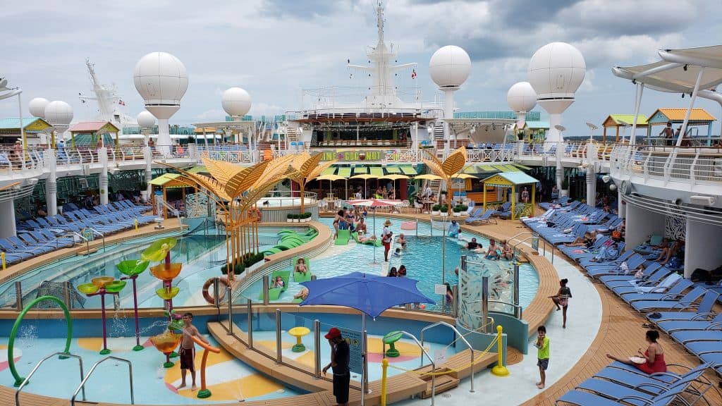 People swimming in a pool on a cruise ship.