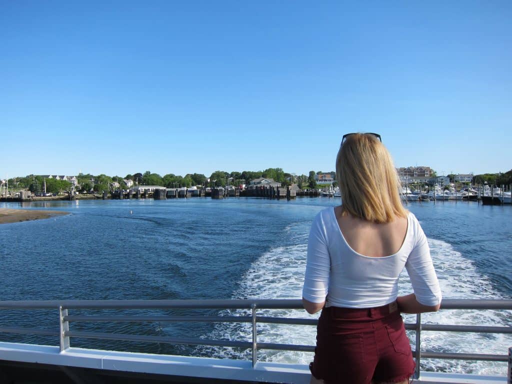 A woman looks out from a boat at the water.