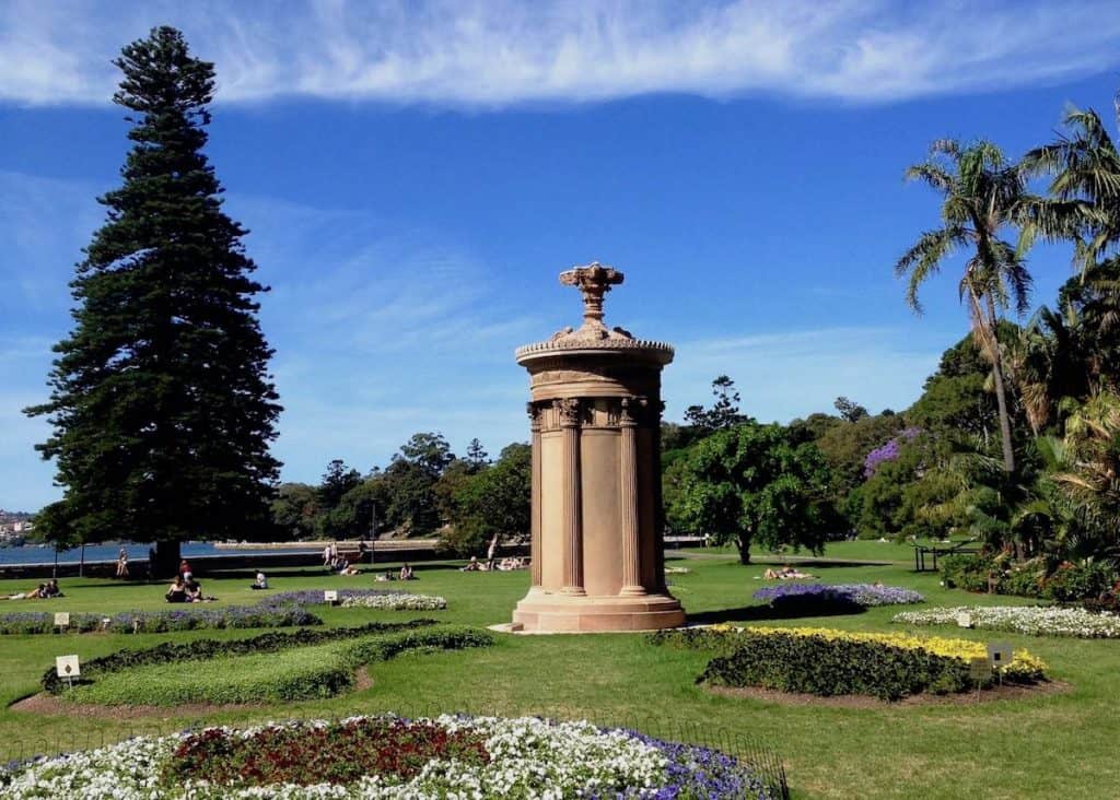 A structure is surrounded by flowers in a garden.