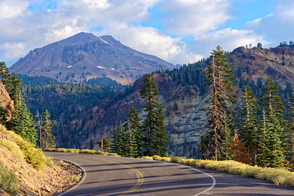 A clear road leads through a mountainous landscape.
