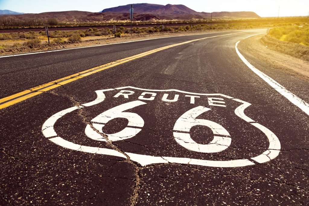 Route 66 sign on the road in the desert.