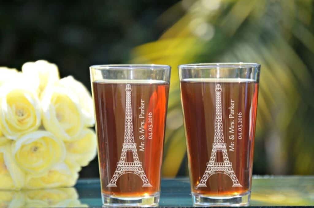 Two glasses filled with a drink feature the Eiffel Tower and the couple\'s wedding date and names.