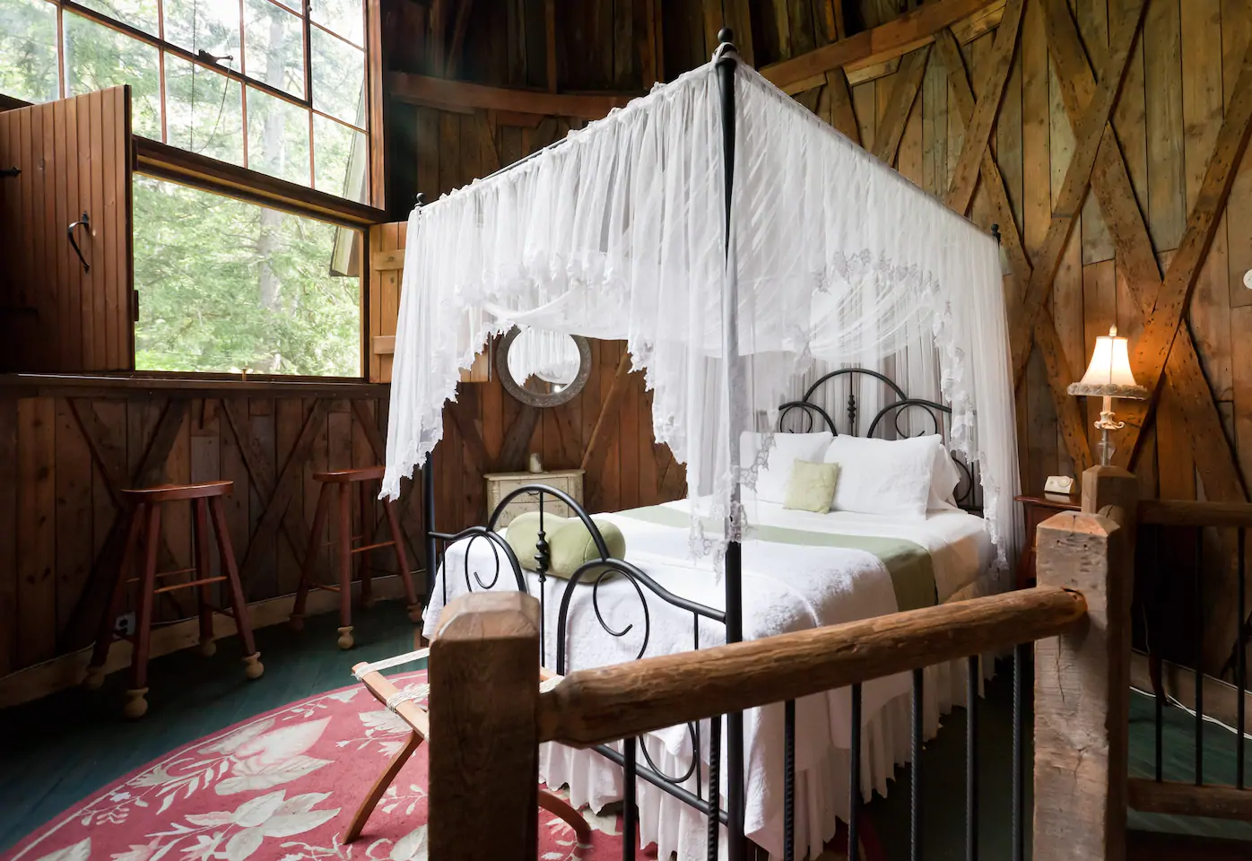 A white canopy bed is in a wooden room.