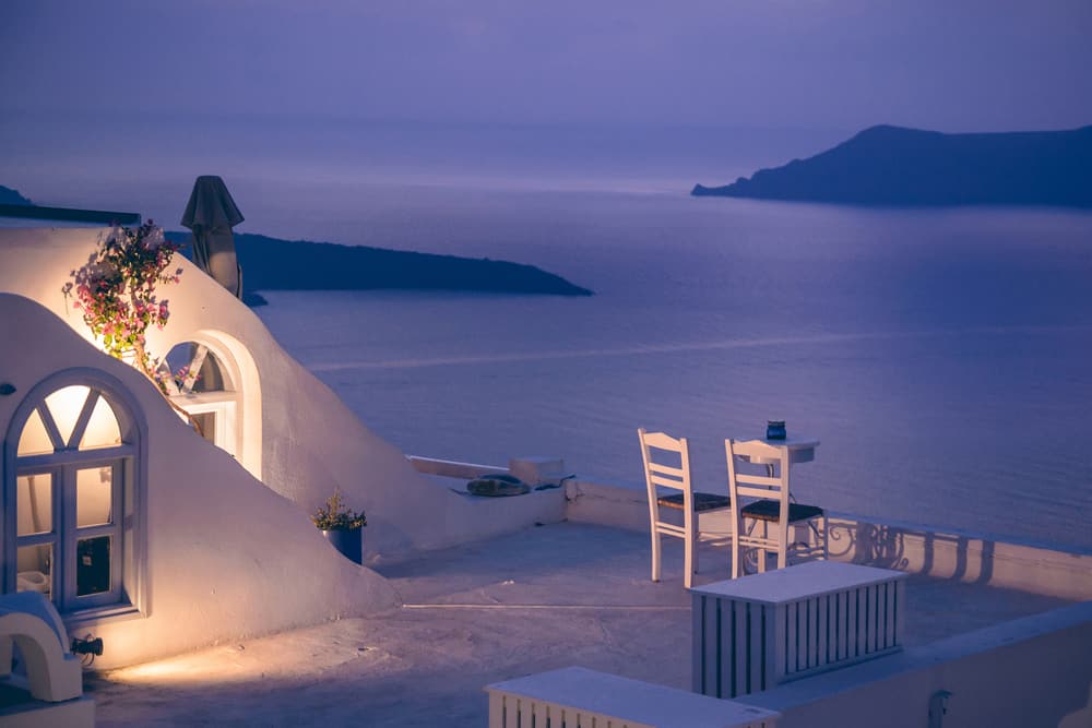 Romantic dinner with a view looking out to the water under a purple sky.