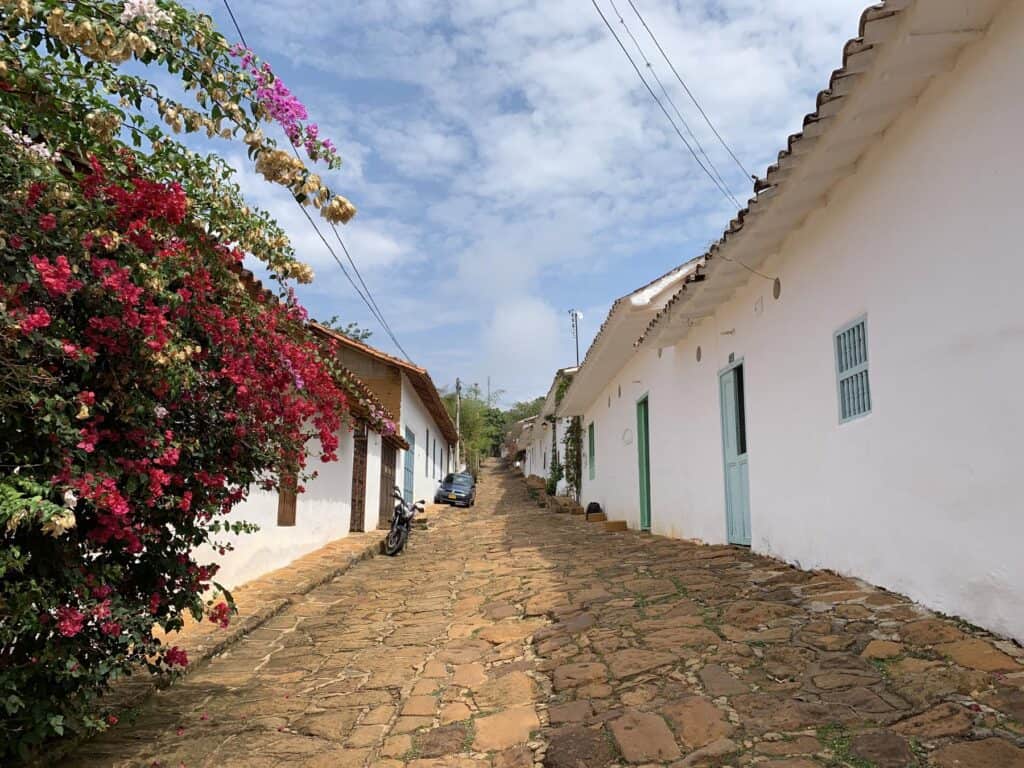 Cobblestone street lined with white buildings.