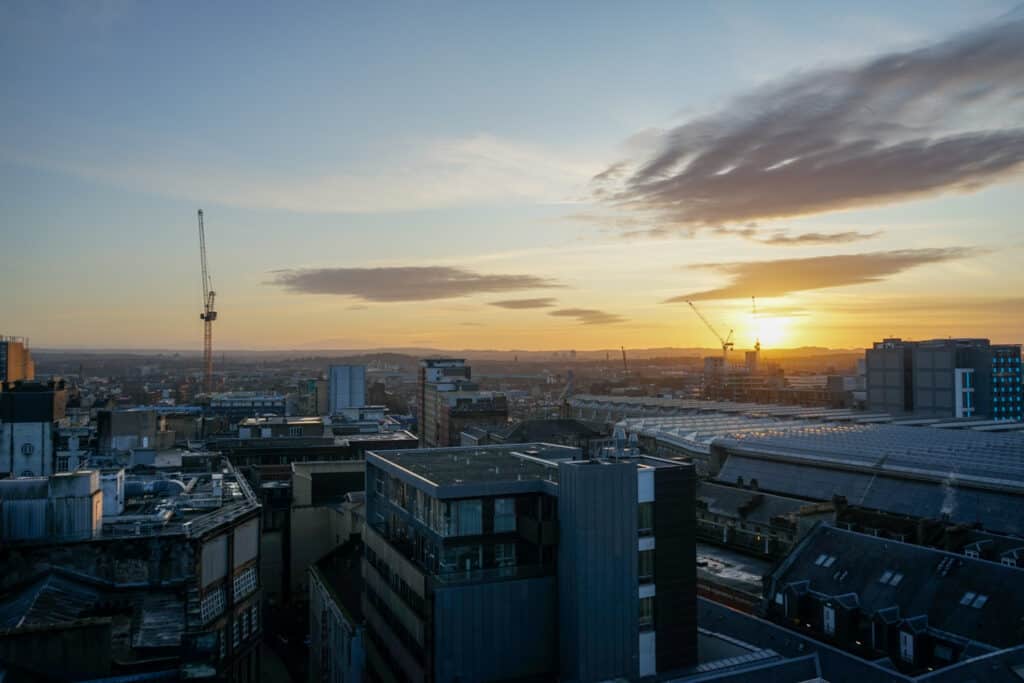 View of a city from above as the sun sets in the distance.