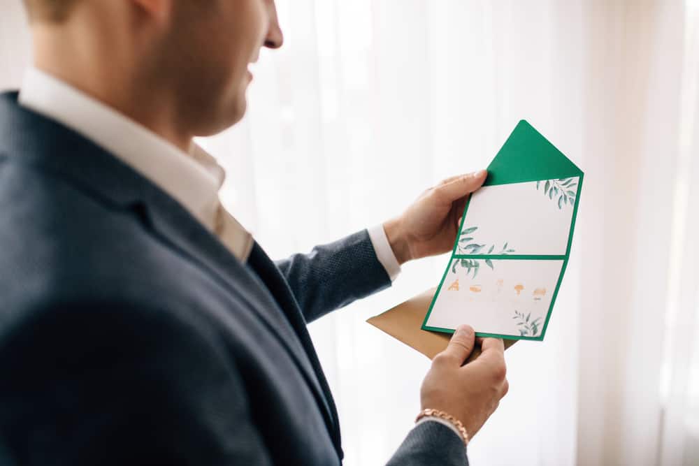 A man opens a green letter.