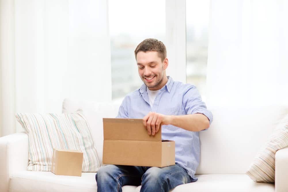 A man opens a brown box.