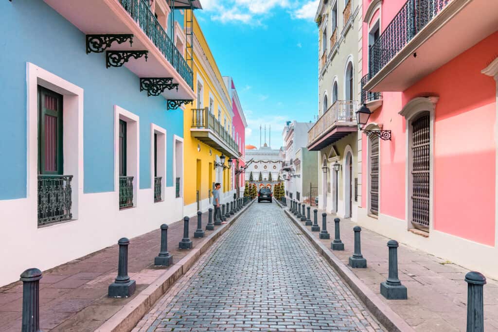 Small brick road with bright, colorful houses on either side. 