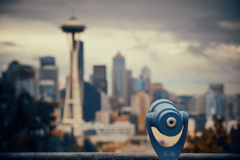 View of a telescope with a city skyline blurred out behind.