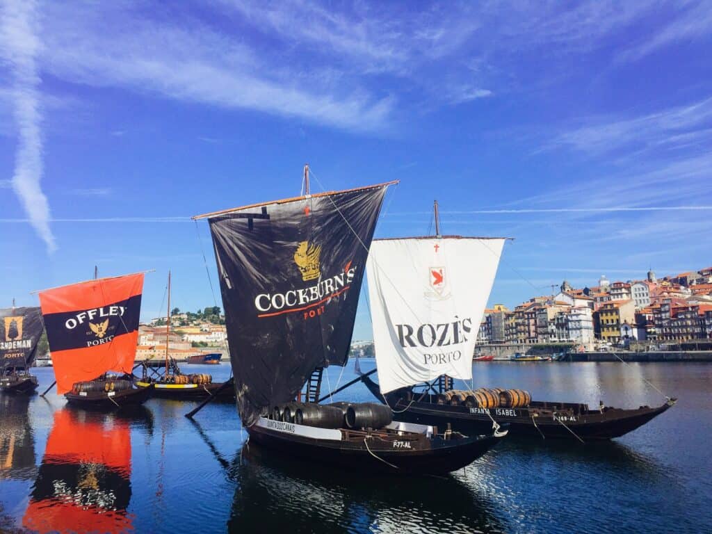 Black boat with two big sails on them.