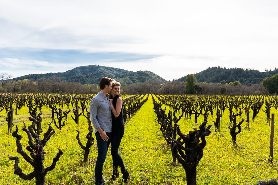 A man and woman standing on a grass field posing for the camera