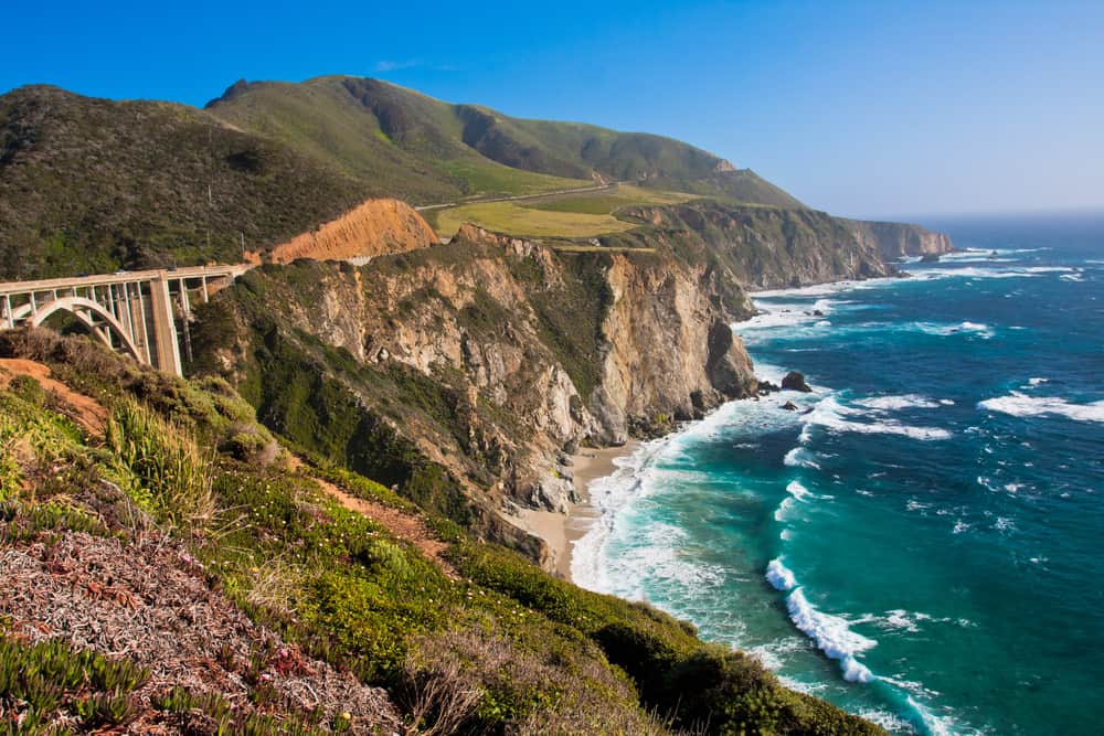 Coastal view of large cliffs by the turquoise ocean.