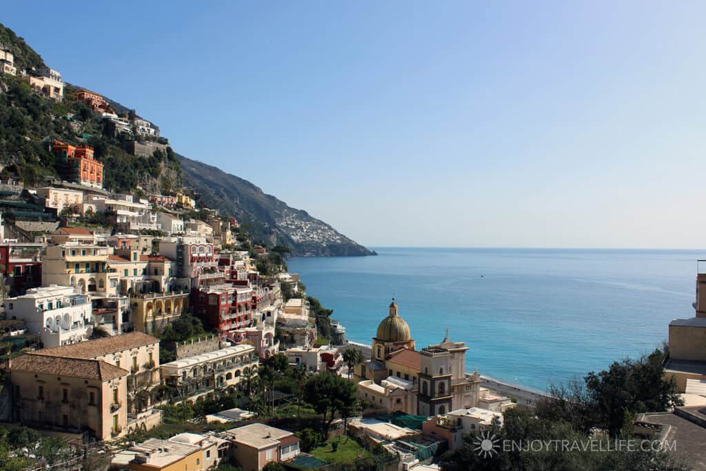 A small cliffside town right on the edge of bright blue water. 