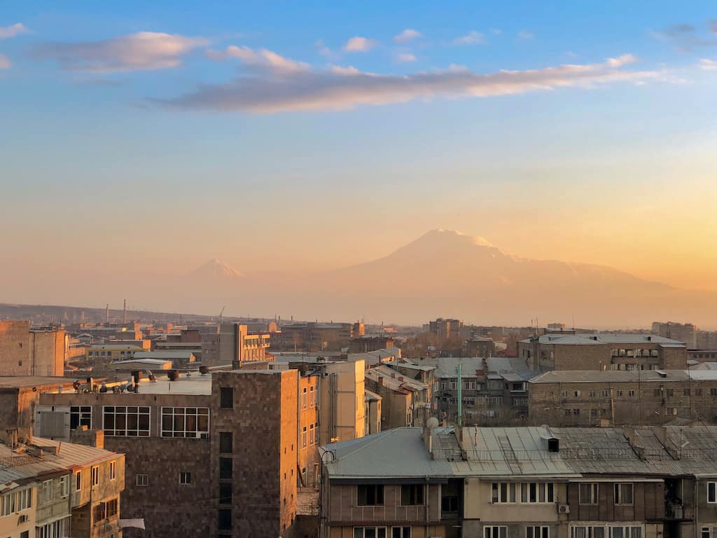 A view looking out over a small city with a mountain in the distance. 