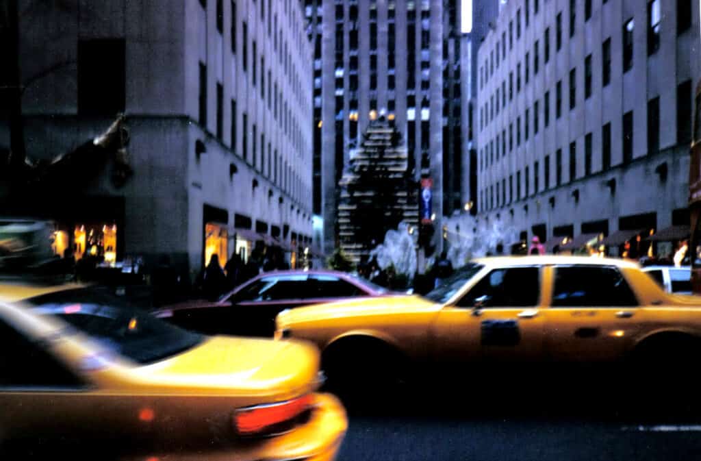 Taxi cars rush past in New York City.