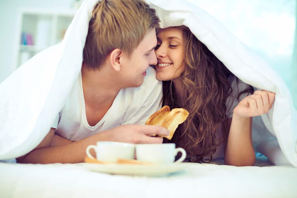 communication in relationships - Couple enjoying one another while having breakfast in bed