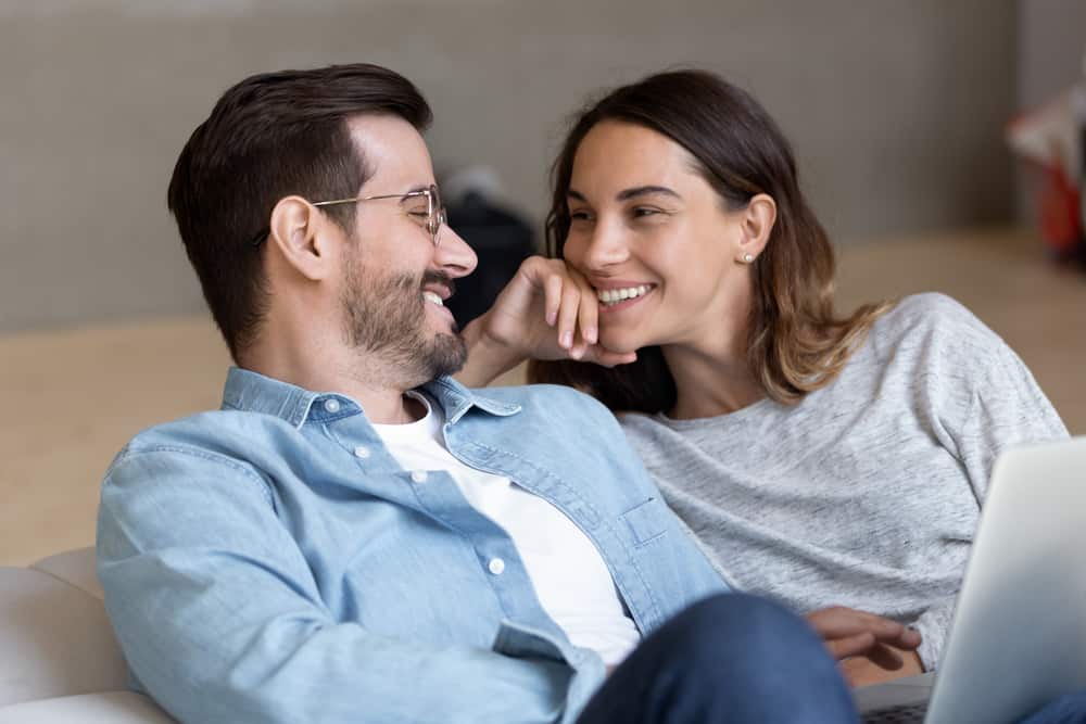 A man and woman smile while chatting.