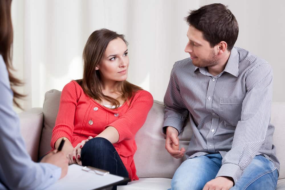 A man chats with a woman at a therapy session.