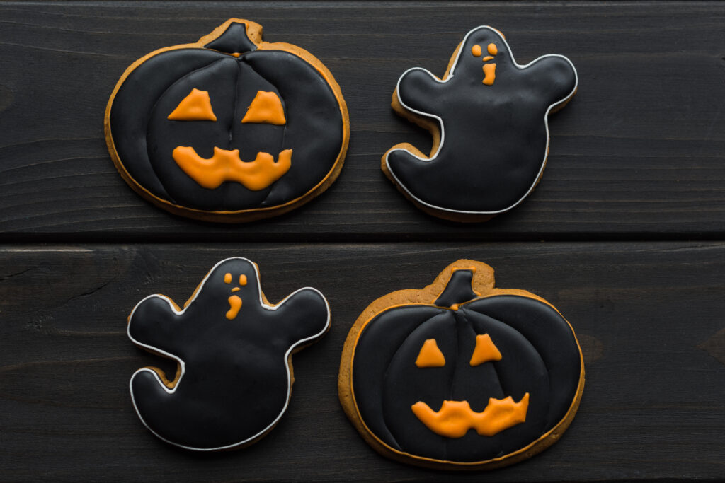 There are four Halloween cookies on the table.