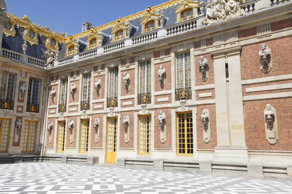 Historic building with golden accents next to a black and white ground.