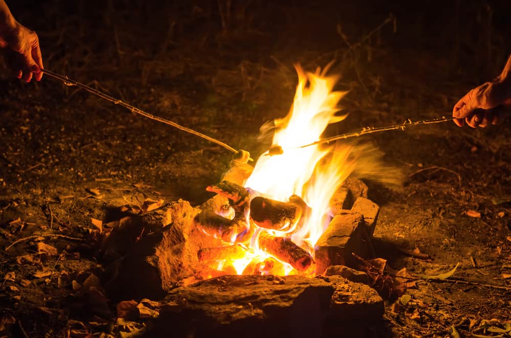 Close up of marshmallows being roasted over a fire outdoors.