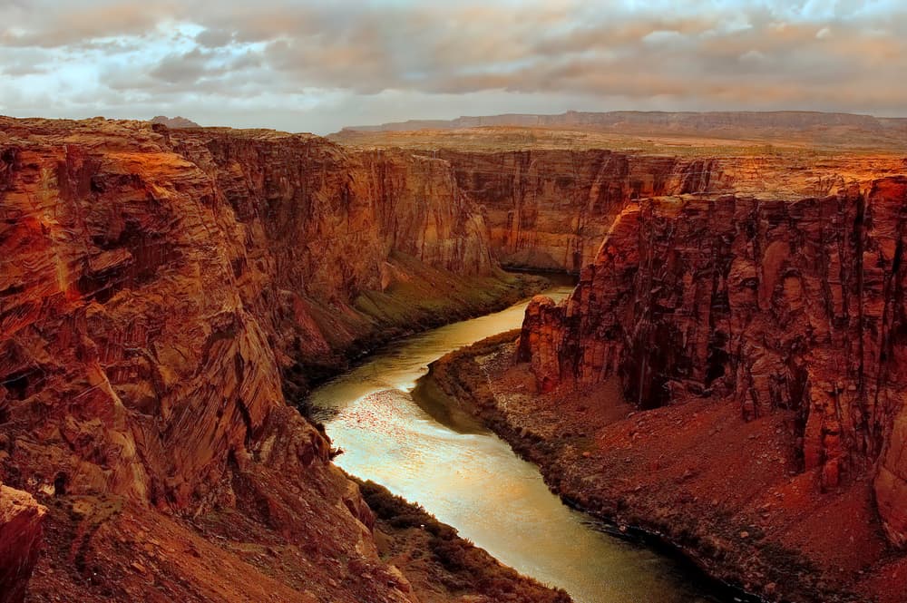 A river breaks through a deep red canyon.