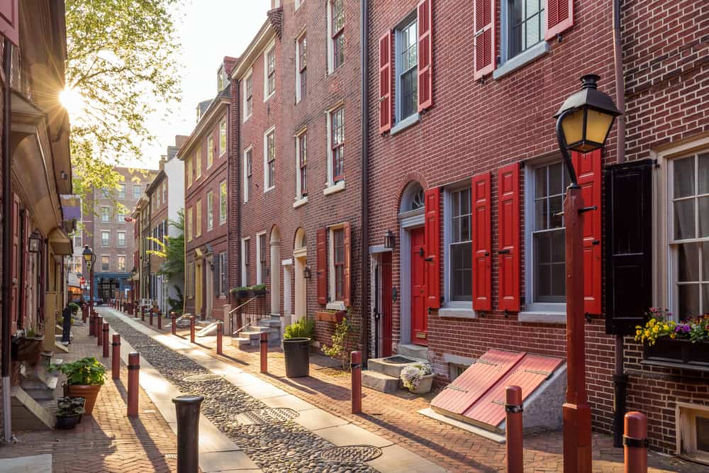 Empty cobblestone path is lined by brick buildings