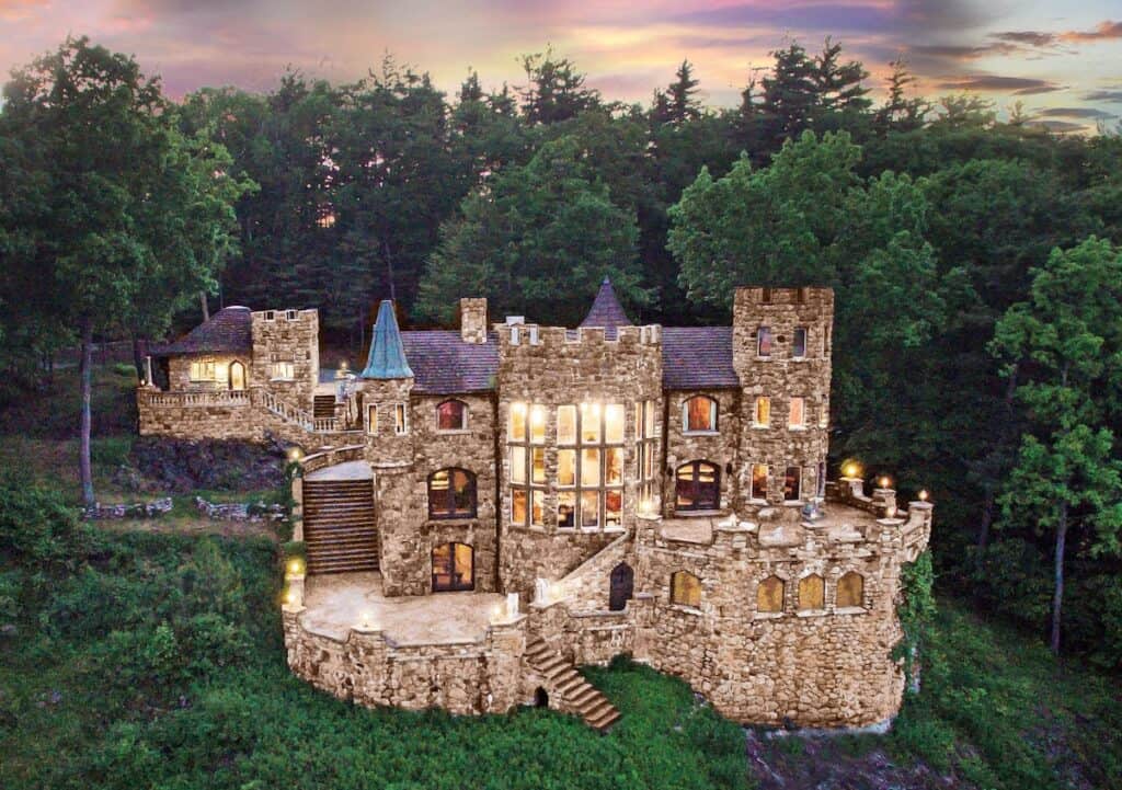 Brick castle-like building surrounded by trees under a purple sky.